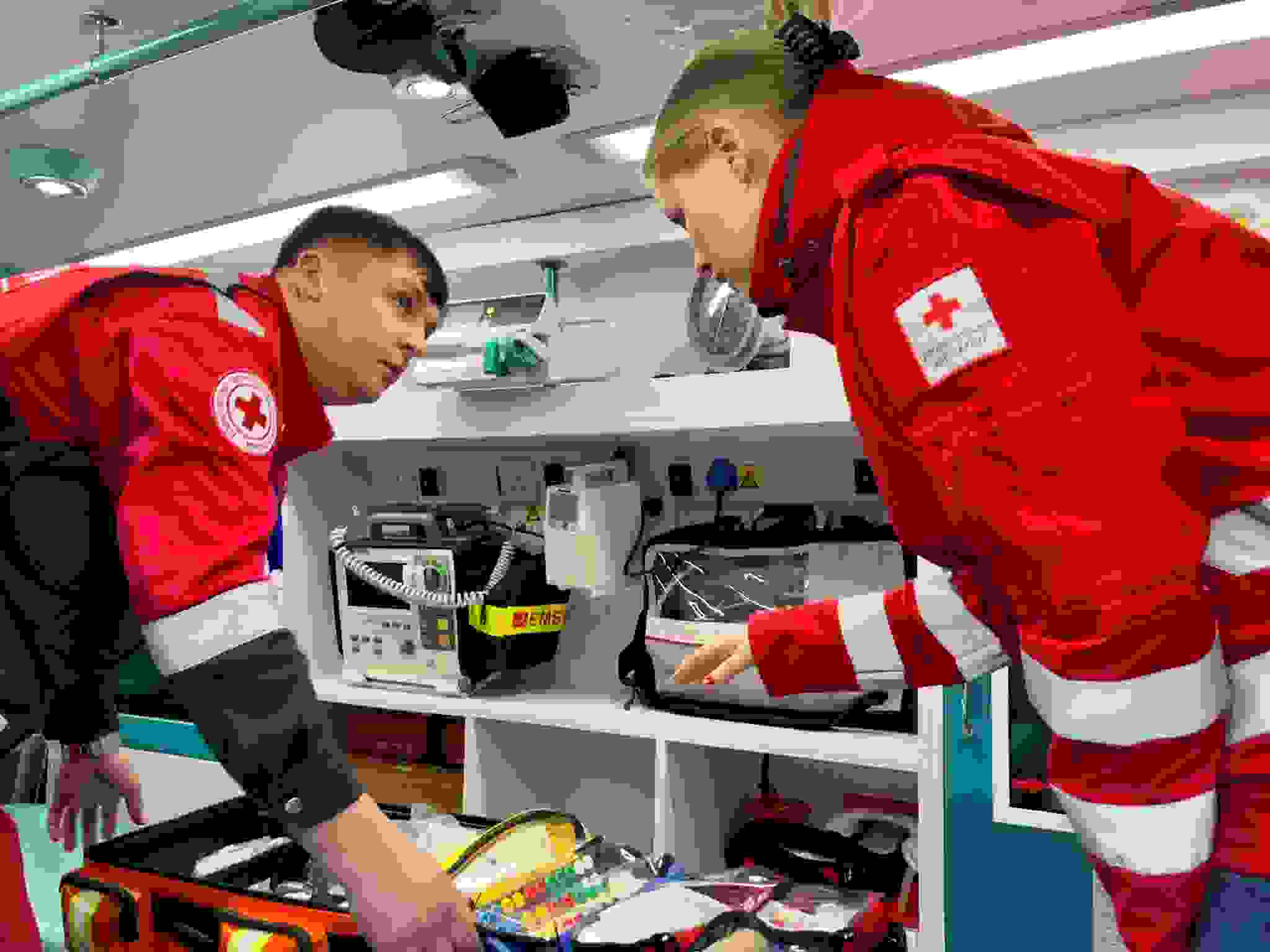 Kaksi Punaisen Ristin avustustyöntekijää ambulanssissa.