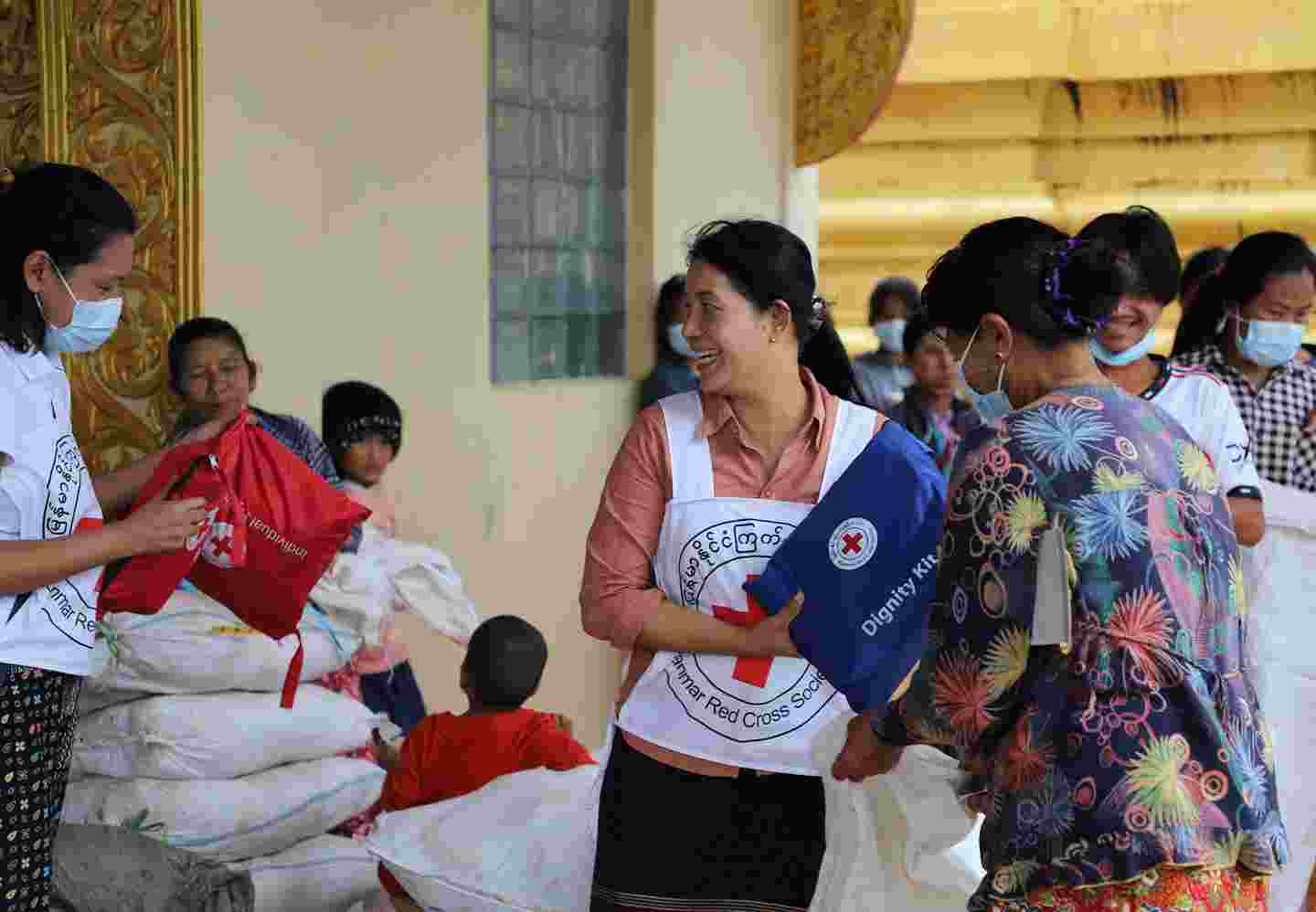 Punaisen Ristin vapaaehtoinen jakaa avustuspaketteja.