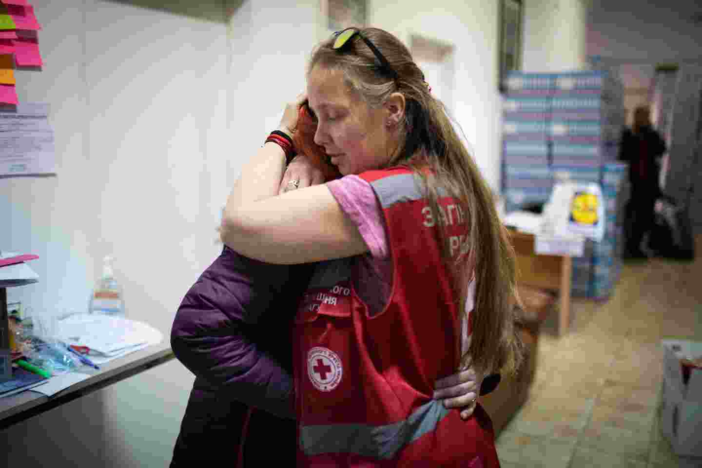Punaisen Ristin vapaaehtoinen halaa ihmistä.