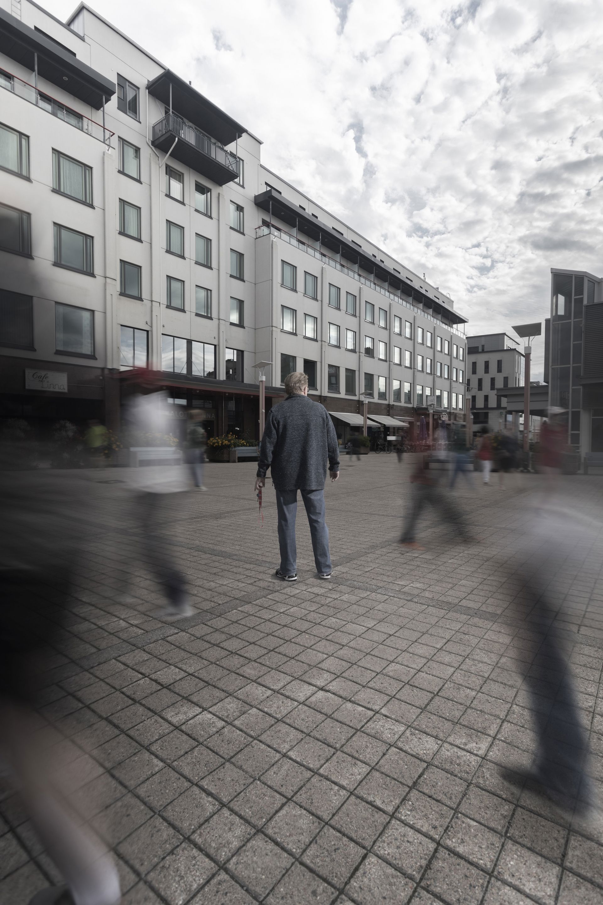 Henkilö seisoo toriaukiolla kädessään Punaisen Ristin avainketju.