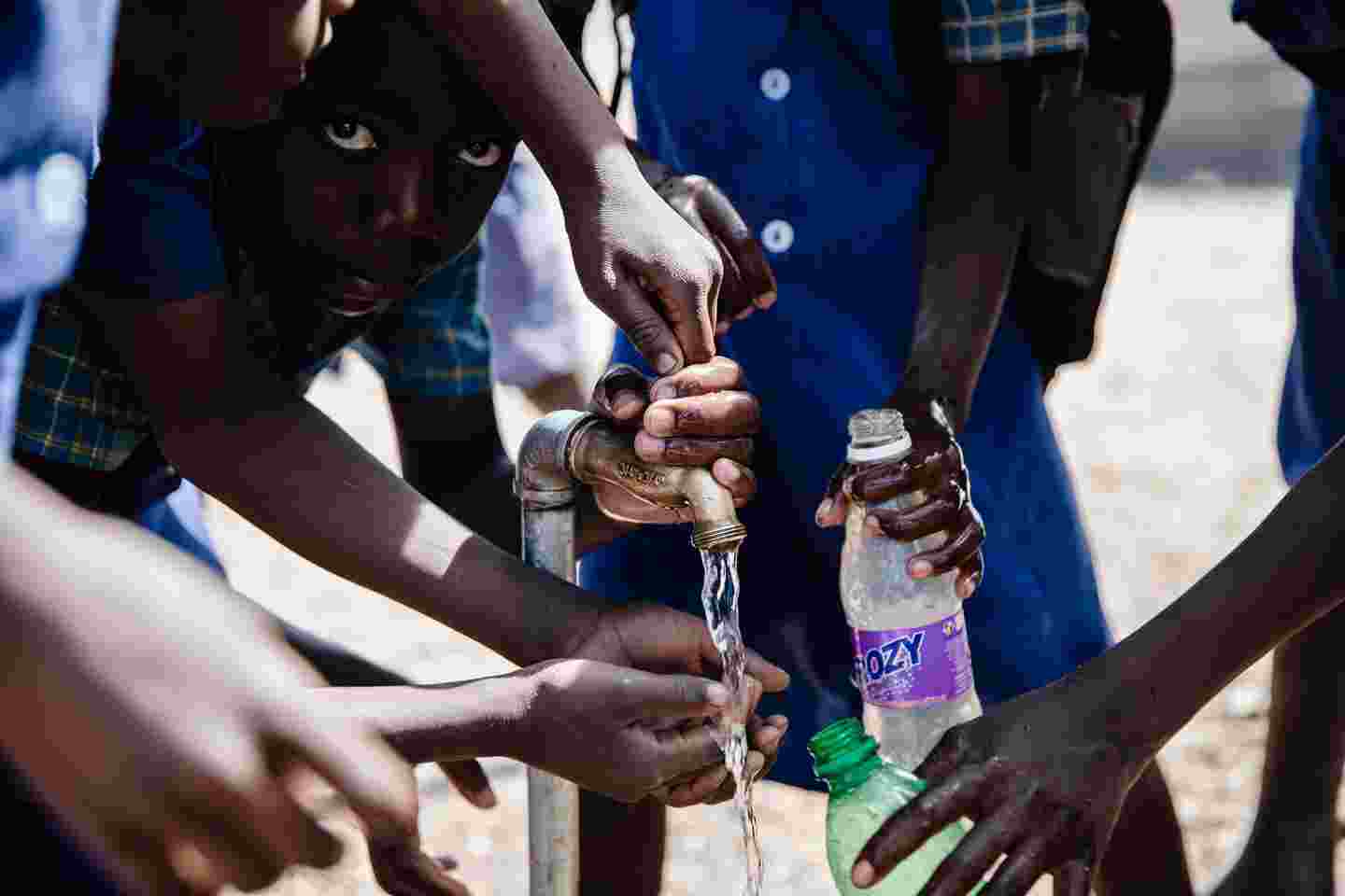 Lapsia täyttämässä vesipulloja.