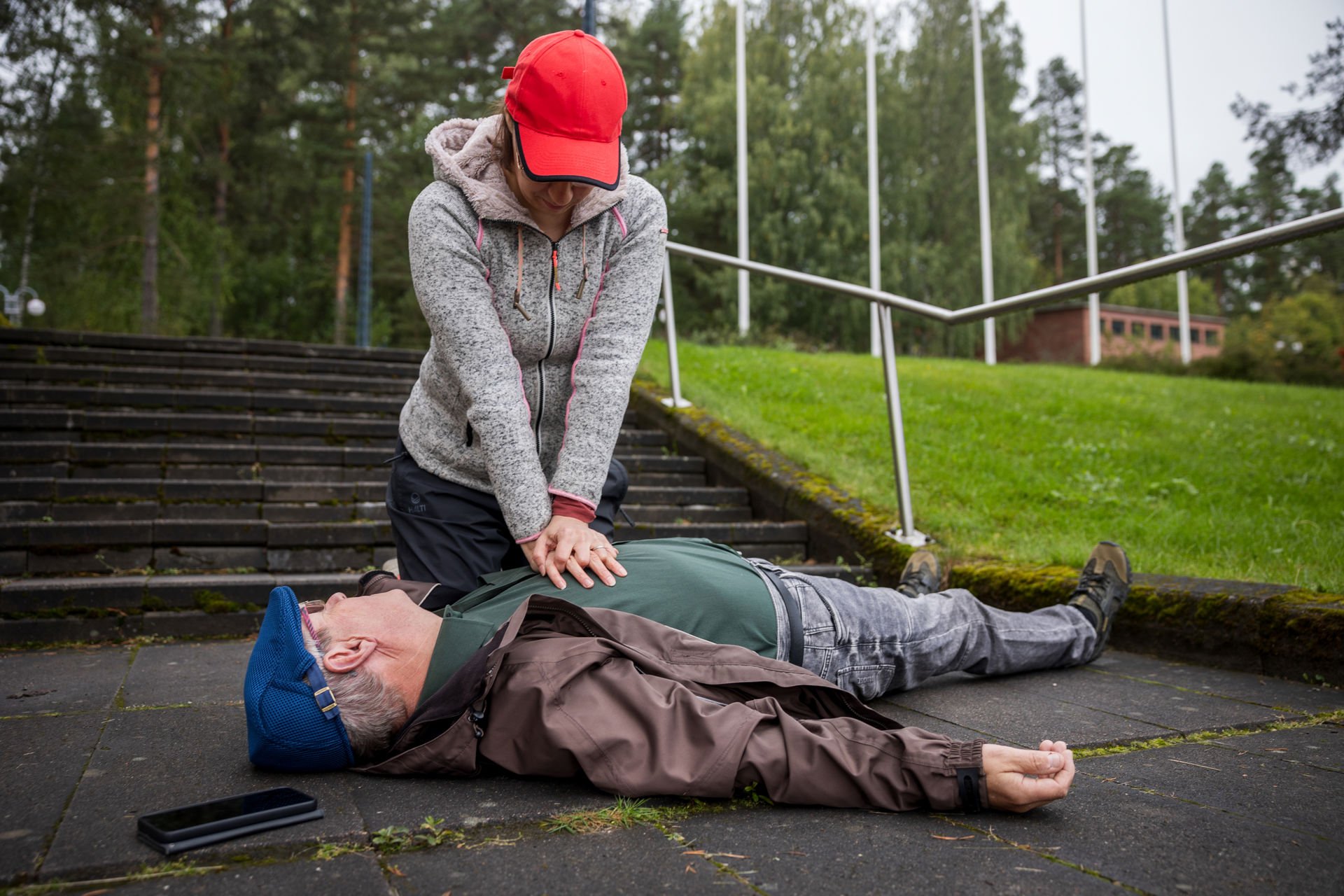 Henkilö antaa iäkkäälle henkilölle paineluelvytystä.