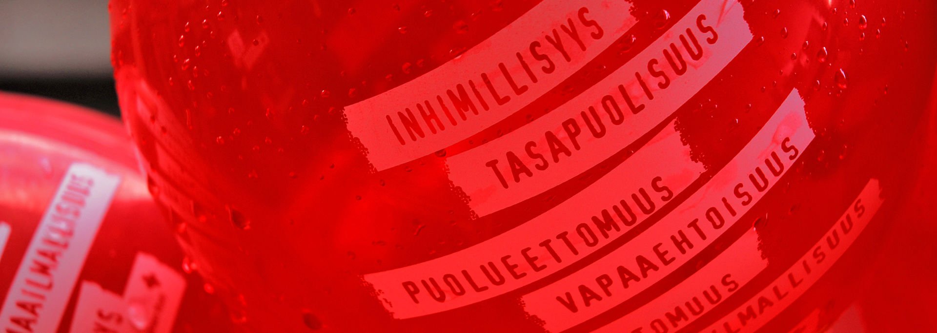 Punaisessa ilmapallossa lukee allekkain kaikki Punaisen Ristin periaatteet.